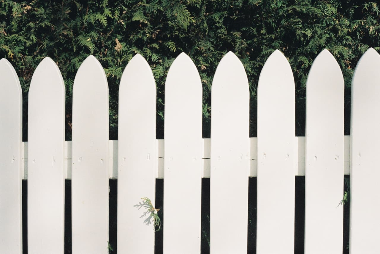 Clôture en panneaux rigides gris dans un jardin — vue de face depuis la rue