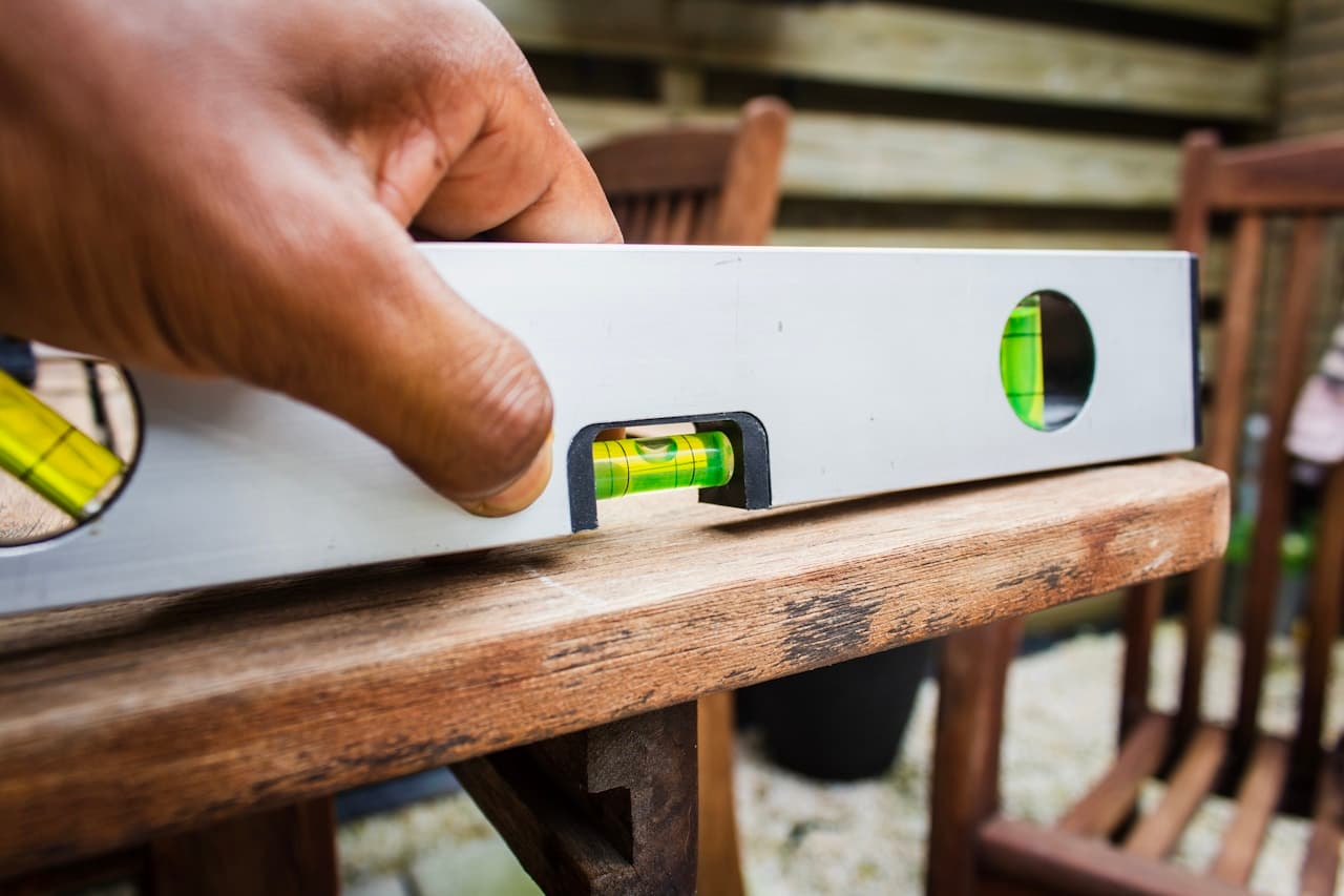 Niveau à bulle posé sur une planche de terrasse en bois — mesure du niveau avant pose